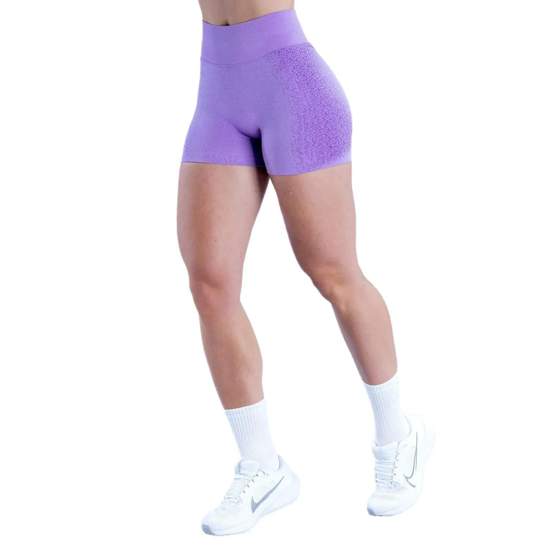Woman wearing purple seamless high-waisted gym shorts, white socks, and white sneakers