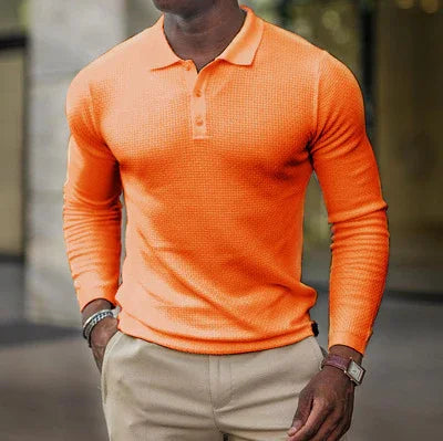 Man wearing fitted orange long-sleeve polo shirt with beige pants outdoors