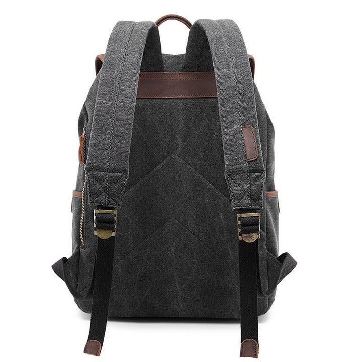 Dark gray canvas backpack with padded straps, leather accents, and adjustable black buckles shown from back