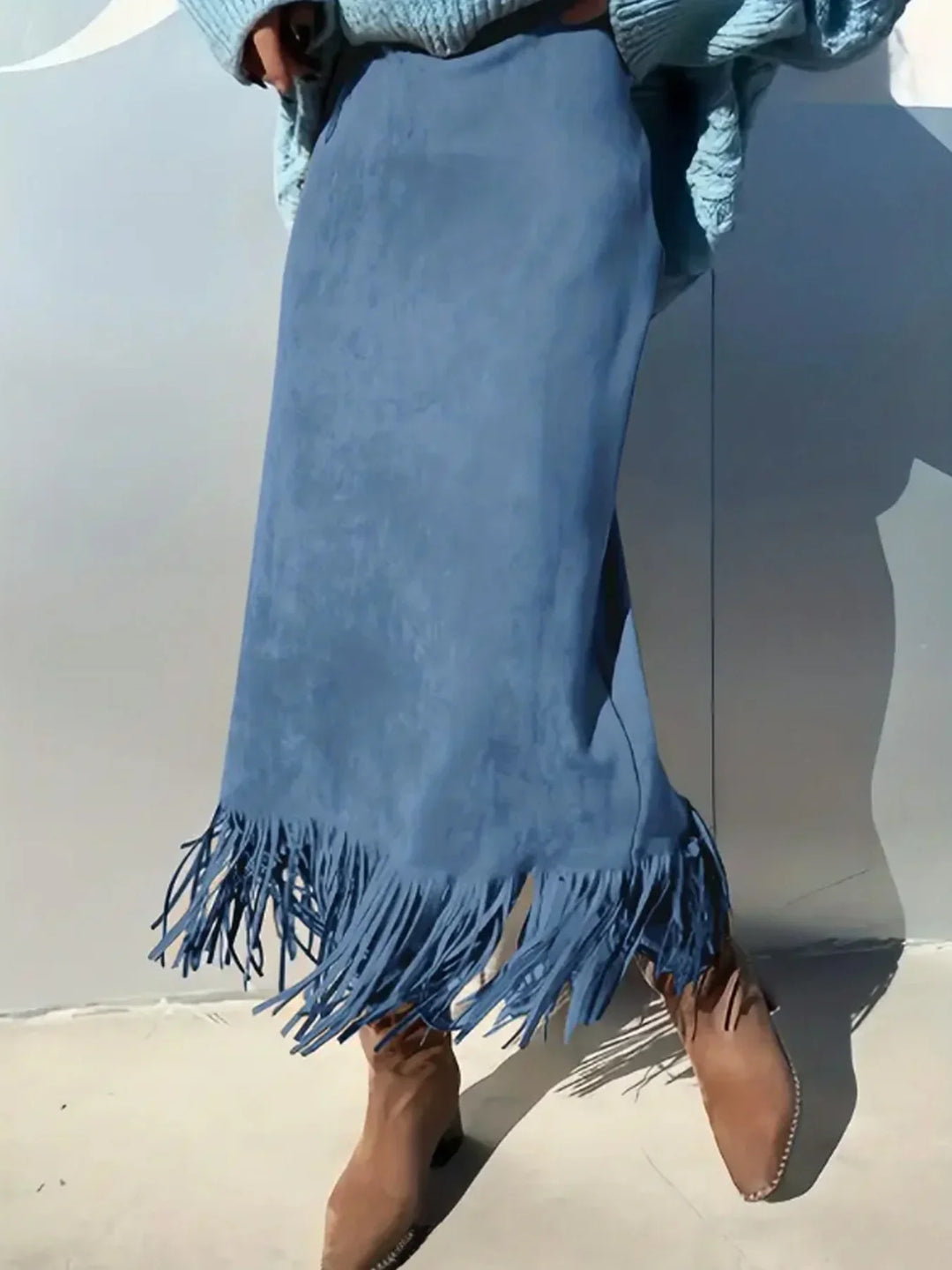 Blue suede fringed skirt paired with brown suede boots in natural light