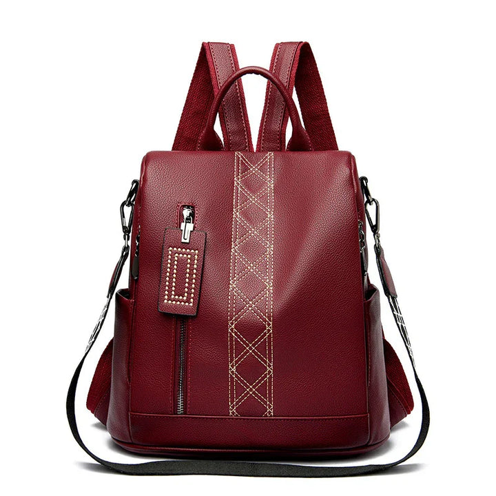 Stylish maroon leather backpack with front zipper pocket and decorative stitching