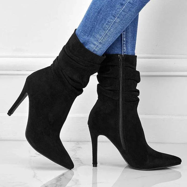Black suede slouchy ankle boots with pointed toe and stiletto heel worn with blue jeans