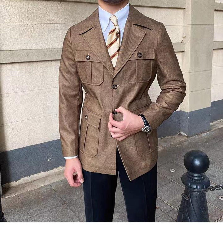 Man wearing brown buttoned blazer with flap pockets, striped tie, white shirt, and black pants in urban setting