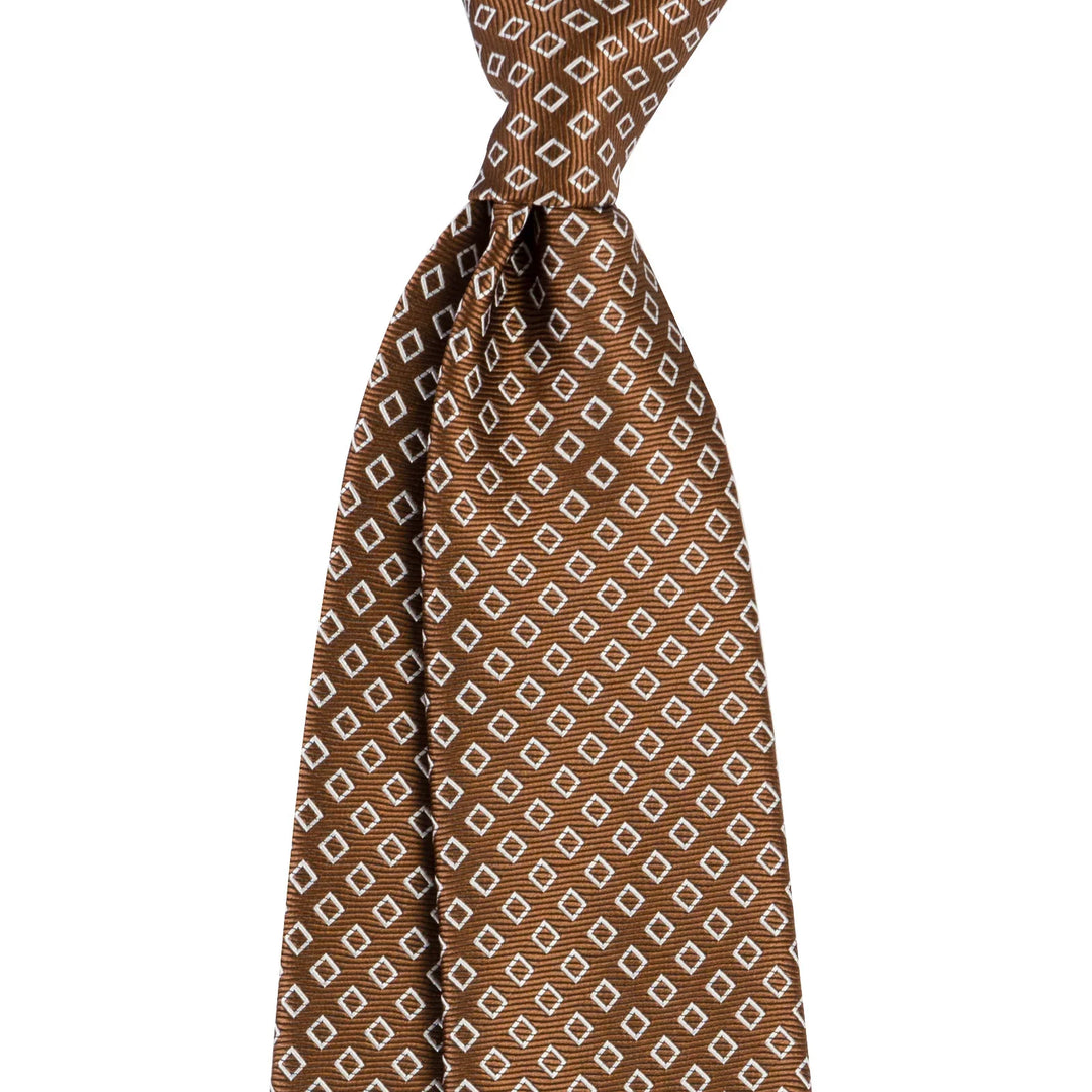 Brown silk necktie with white diamond pattern, tied in classic Windsor knot