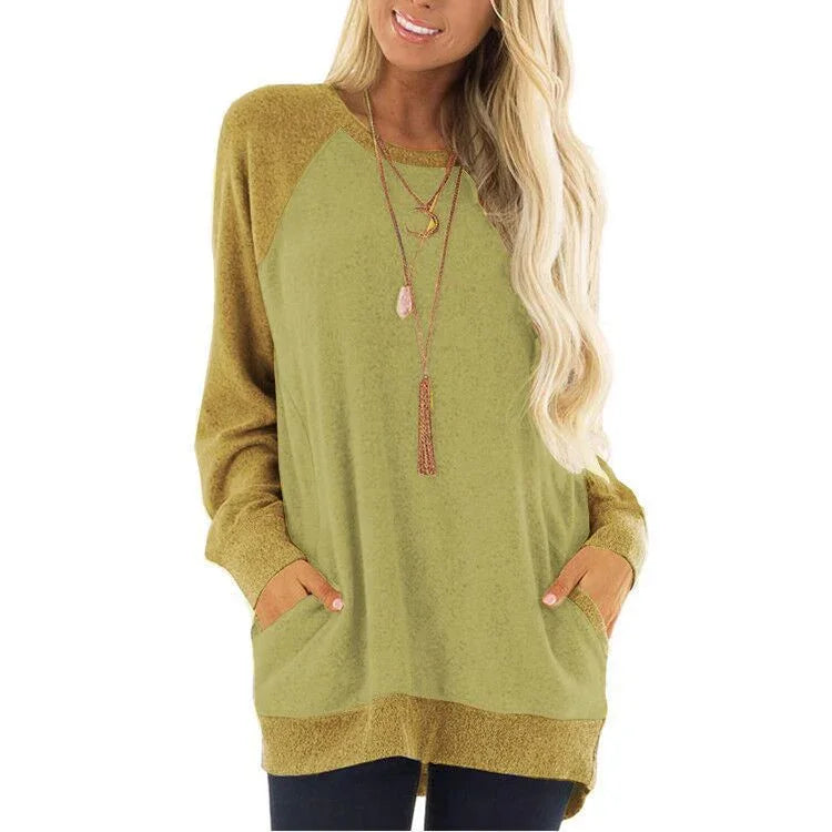 Woman wearing olive green and mustard oversized sweatshirt with pockets and layered necklaces