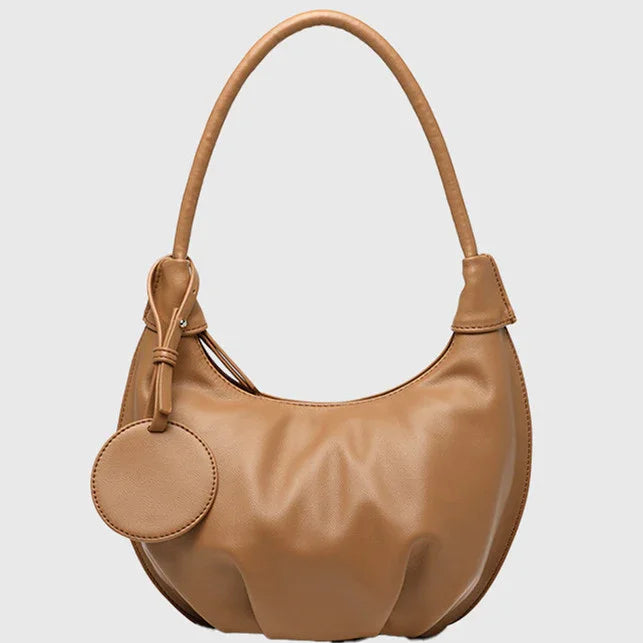 Tan leather crescent shoulder bag with round coin pouch and smooth texture