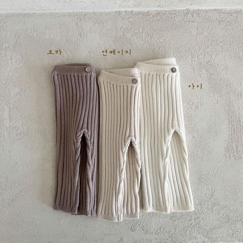 Three pairs of ribbed knit pants in mocha, light beige, and ivory with button details on waist