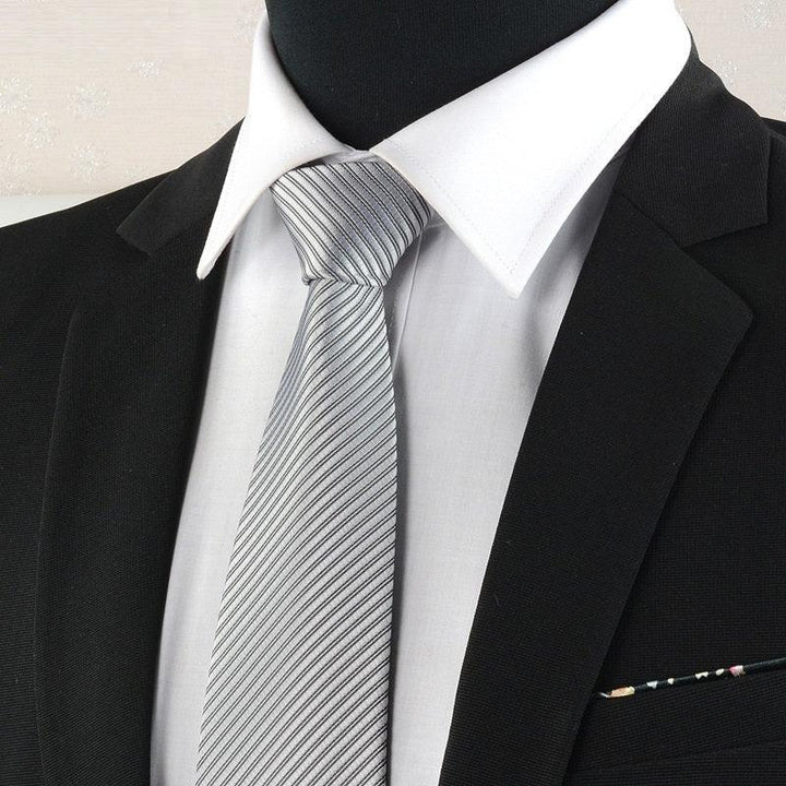 Black suit jacket with white dress shirt and silver striped tie on mannequin