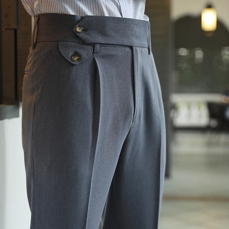 Close-up of tailored dark gray dress pants with double button waistband detail and side pocket