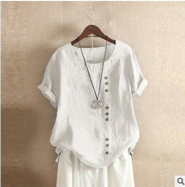 White short-sleeve linen blouse with side button details and pendant necklace on wooden hanger