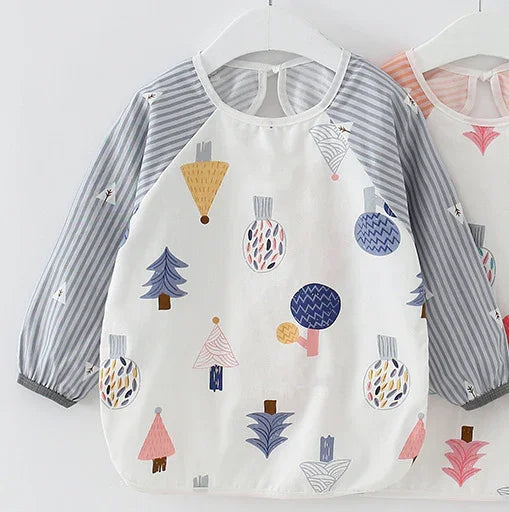 Children's long-sleeve smock with gray striped sleeves and colorful abstract tree and ornament prints on white body