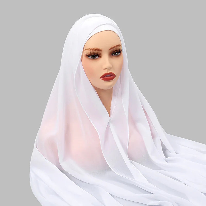 mannequin head wearing a white translucent hijab against a gray background