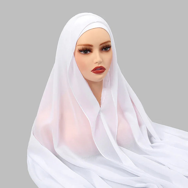 mannequin head wearing a white translucent hijab against a gray background