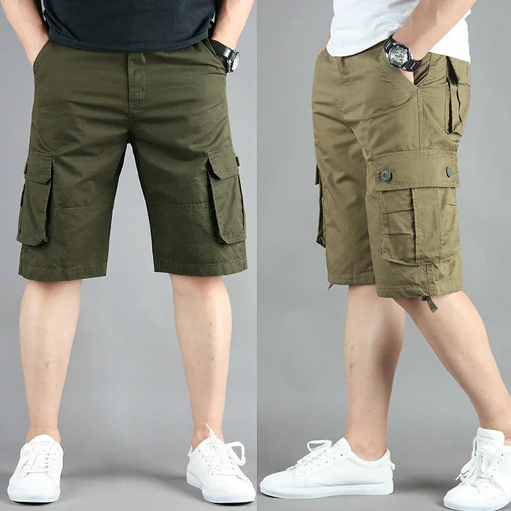 Men's olive green cargo shorts with multiple pockets, worn with white sneakers and black watch