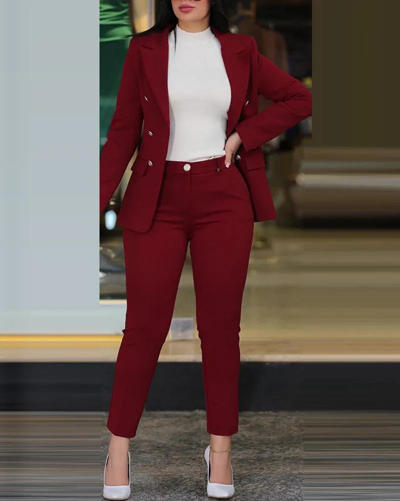 Woman wearing a burgundy double-breasted blazer and slim pants with white high heels and a white top