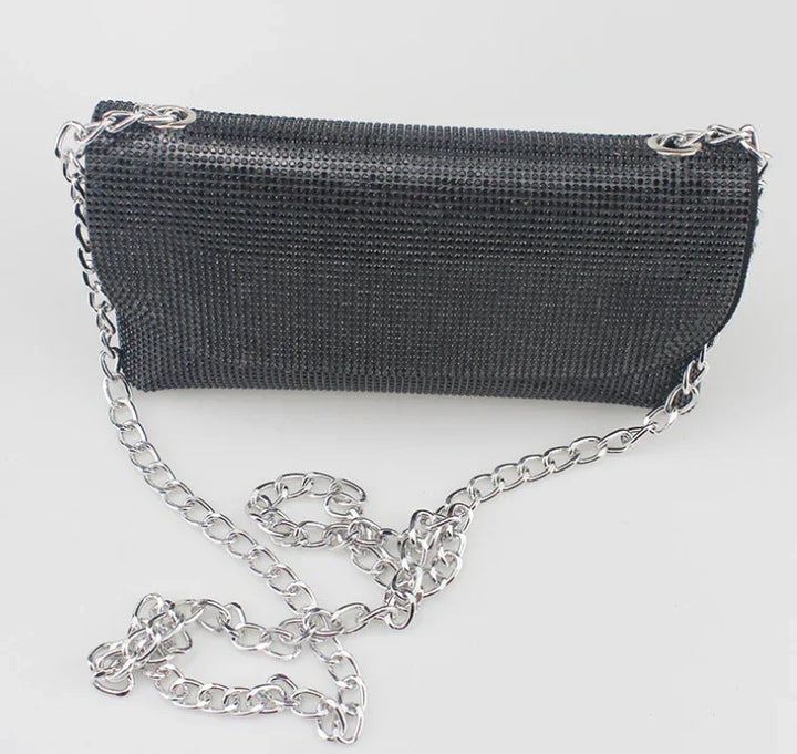 Black mesh evening clutch bag with silver chain strap on white background