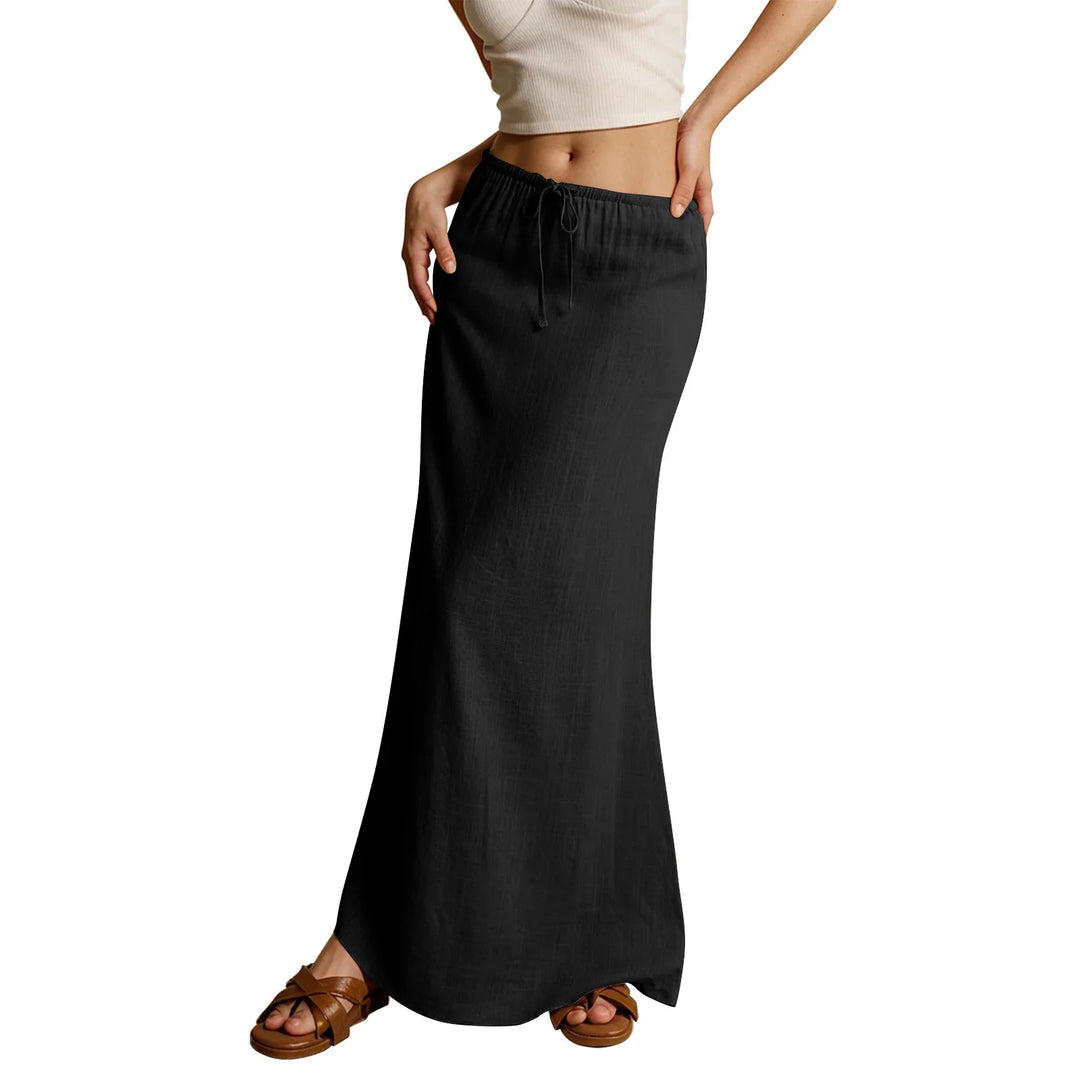 Woman wearing a black drawstring maxi skirt and brown sandals with a cropped white tank top