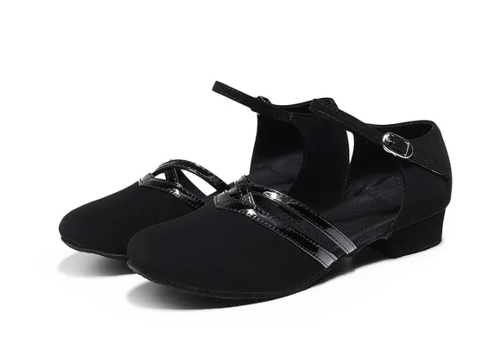 Black women's dance shoes with ankle strap and low heel, featuring shiny cross straps