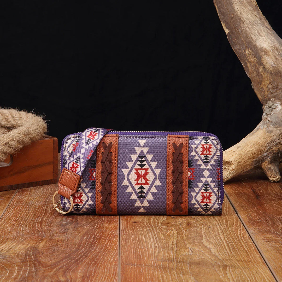 Southwestern style wallet with geometric pattern, leather accents, and wrist strap on wood surface