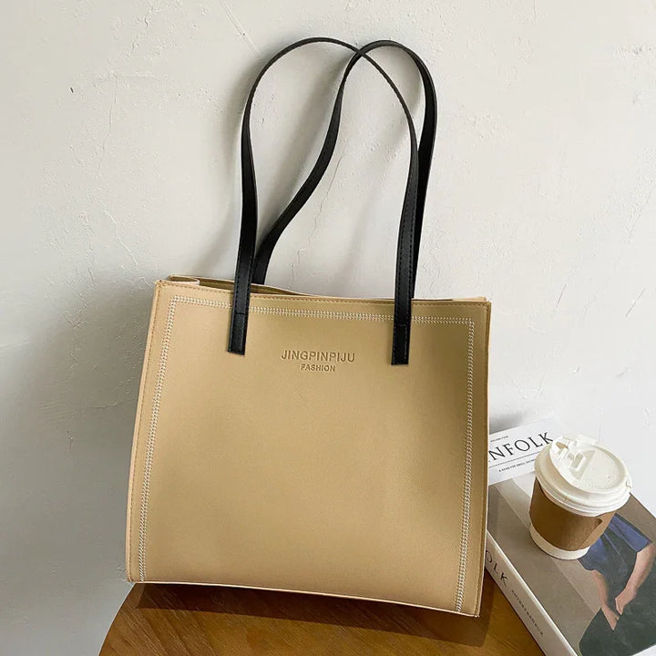 Beige JINGPINPIJU FASHION tote bag with black handles on wooden table next to coffee cup and magazine