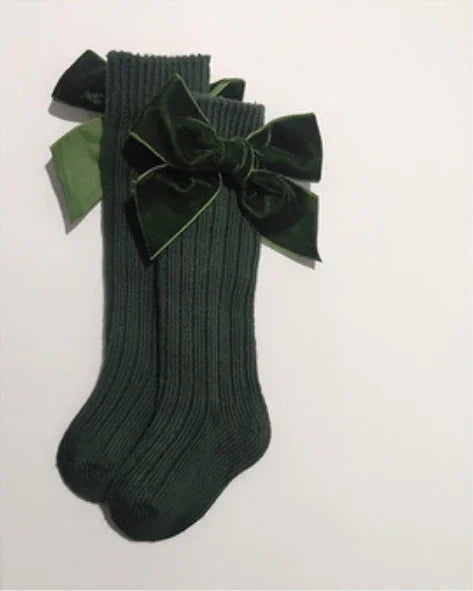 Dark green ribbed knee-high socks with large velvet bows on white background