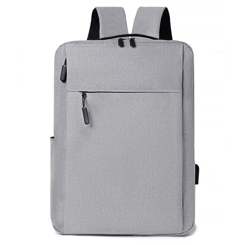 Modern gray backpack with front zipper pocket and padded shoulder straps on white background