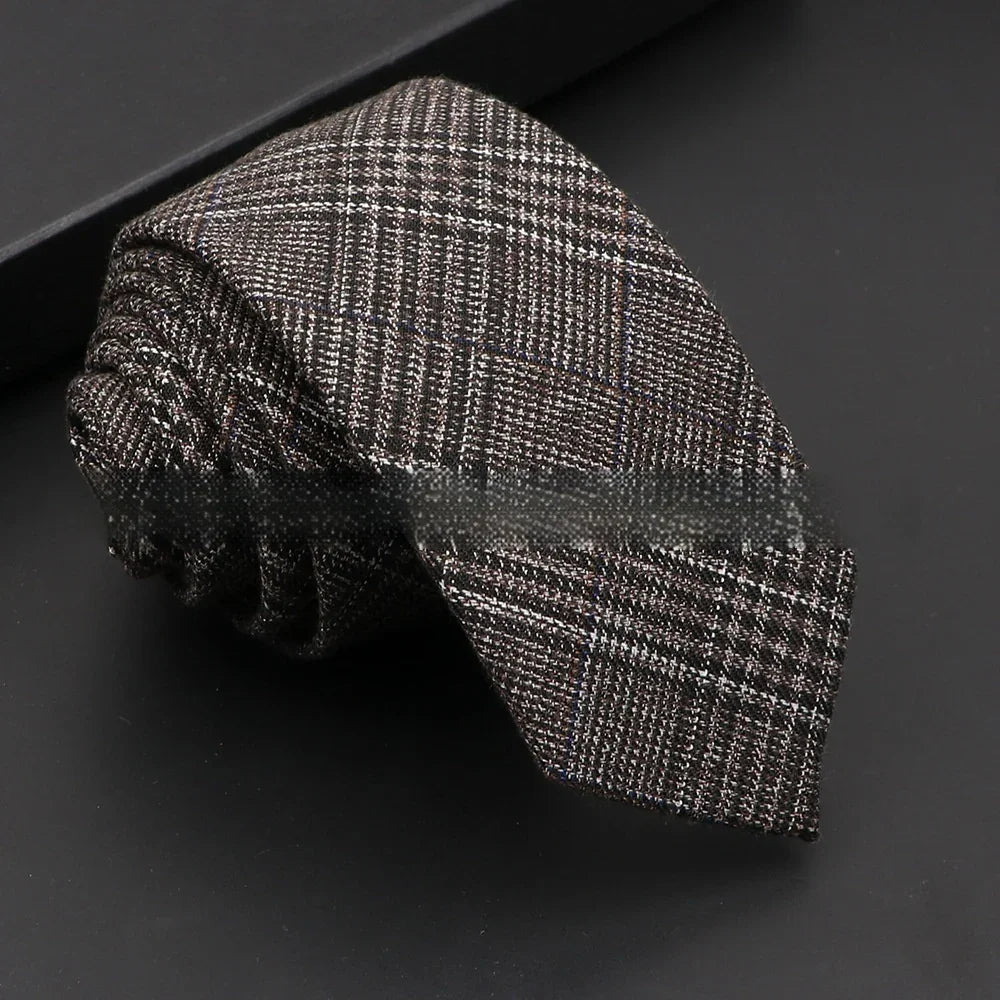 Rolled men's necktie with brown and white plaid pattern on black background