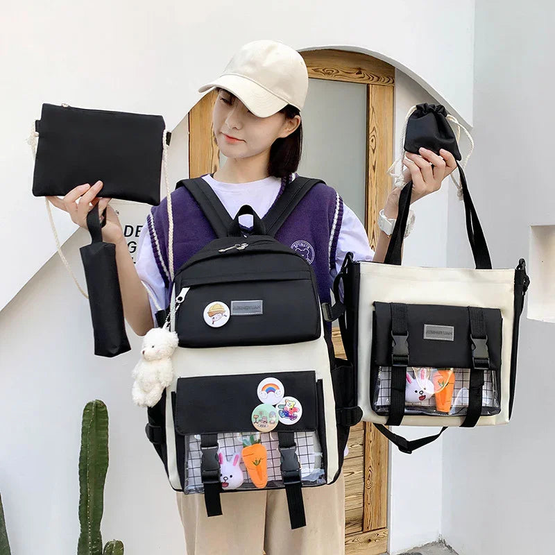 Woman wearing beige cap holding black and white backpack and matching tote bag with cartoon pins and stuffed toy