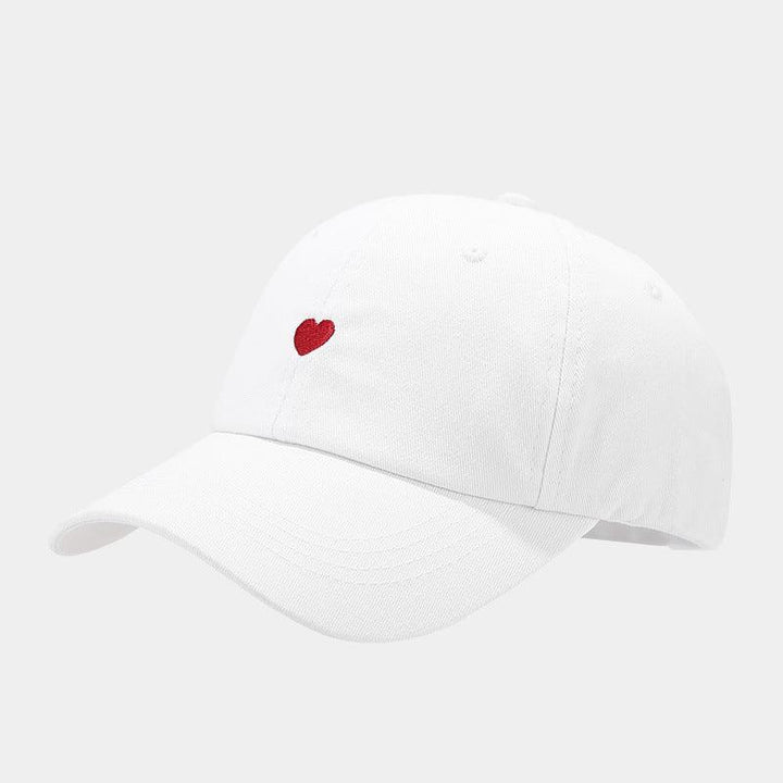 White baseball cap with small red heart embroidered on front panel
