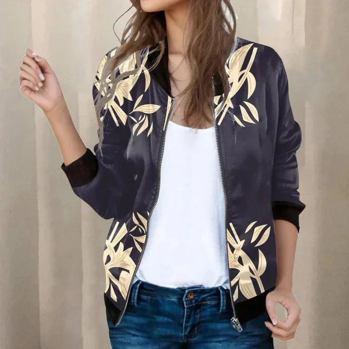 Woman wearing navy bomber jacket with beige floral print, white top, and blue jeans