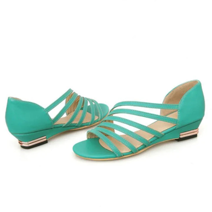 Pair of turquoise flat sandals with multiple thin straps and back heel detail