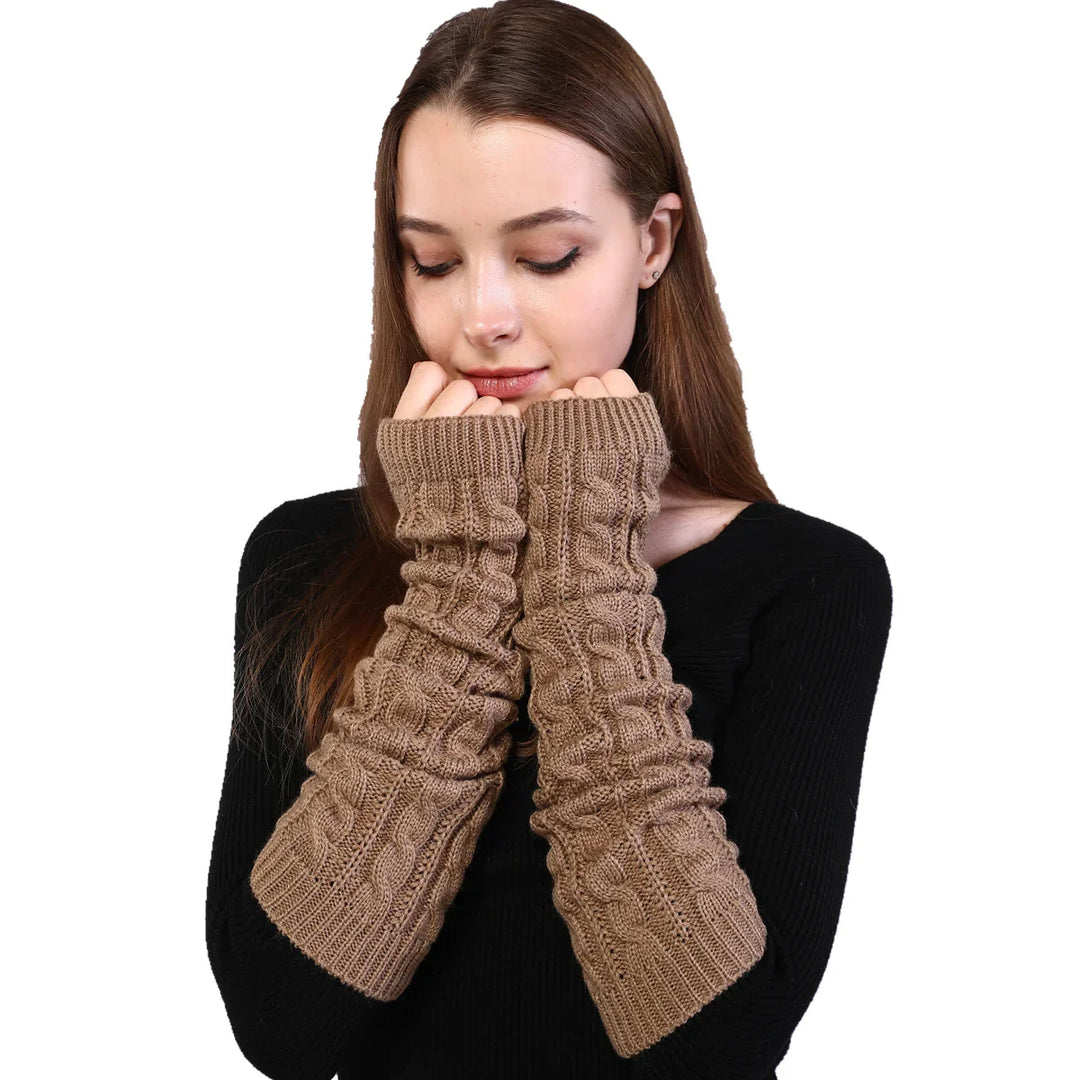 Young woman wearing beige cable knit long arm warmers over black sweater on white background