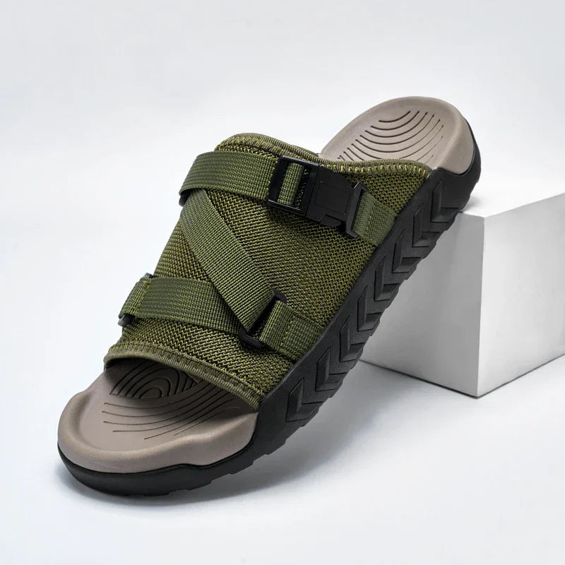 Olive green slide sandal with adjustable straps and textured black sole on white background