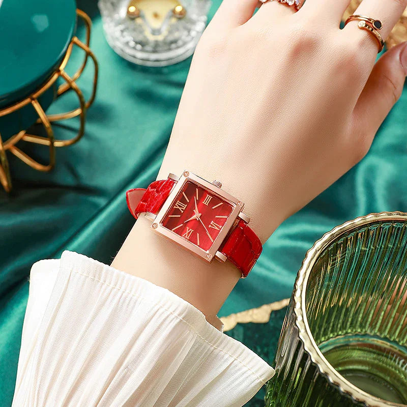 Wristwatch with red leather strap and square red dial with Roman numerals on woman's wrist