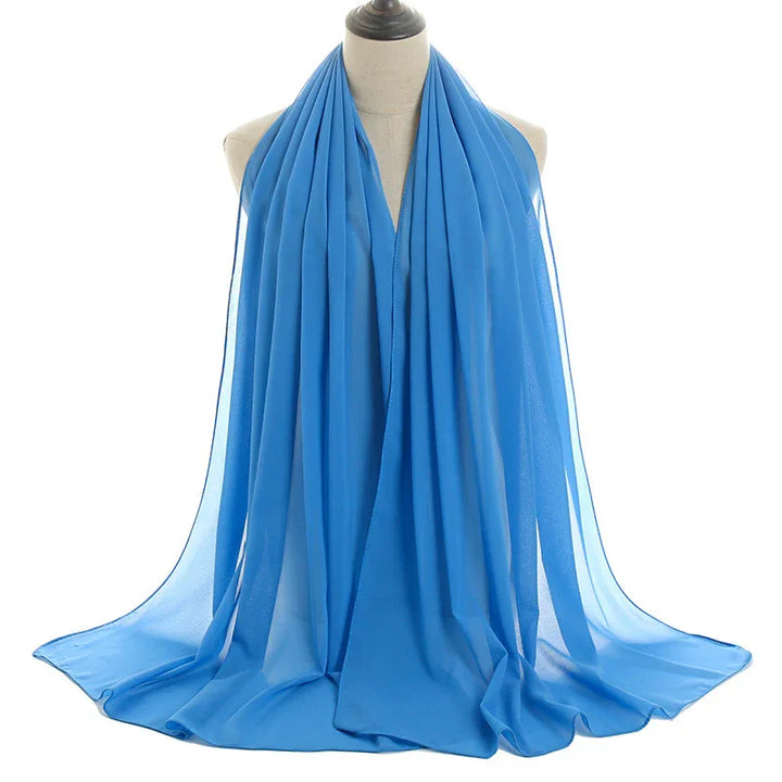 Light blue chiffon scarf draped on mannequin with soft pleats and flowing fabric