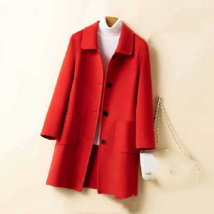 Red wool coat with black buttons styled over white turtleneck sweater, accessorized with white chain strap bag