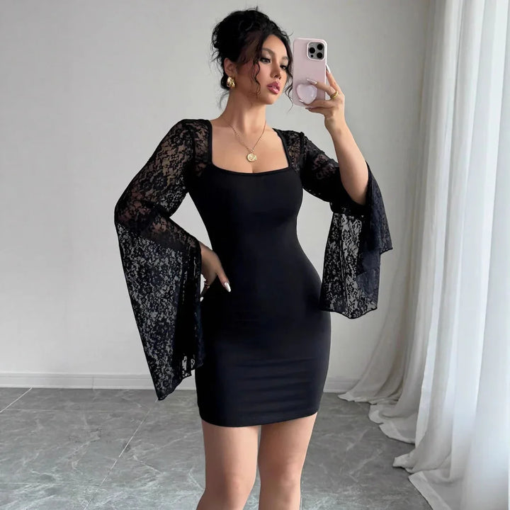 Woman taking selfie wearing black bodycon dress with sheer lace bell sleeves in minimalist room