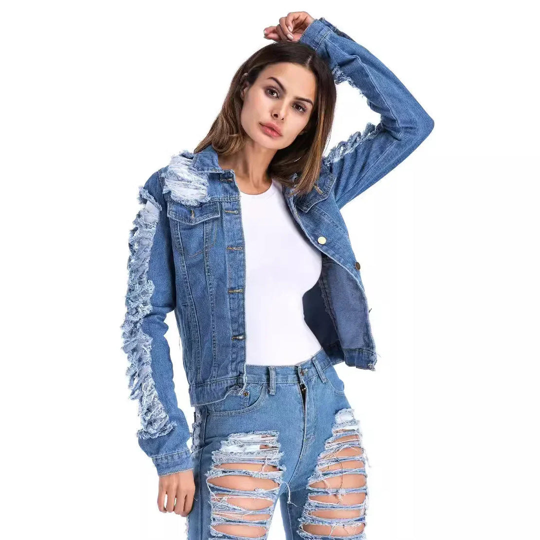 Woman wearing distressed denim jacket and ripped jeans over white top on white background