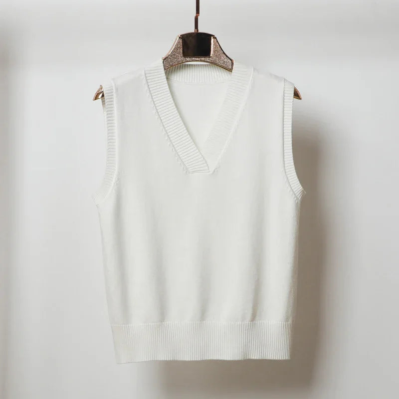 White sleeveless knit sweater vest with V-neck on hanger against plain background