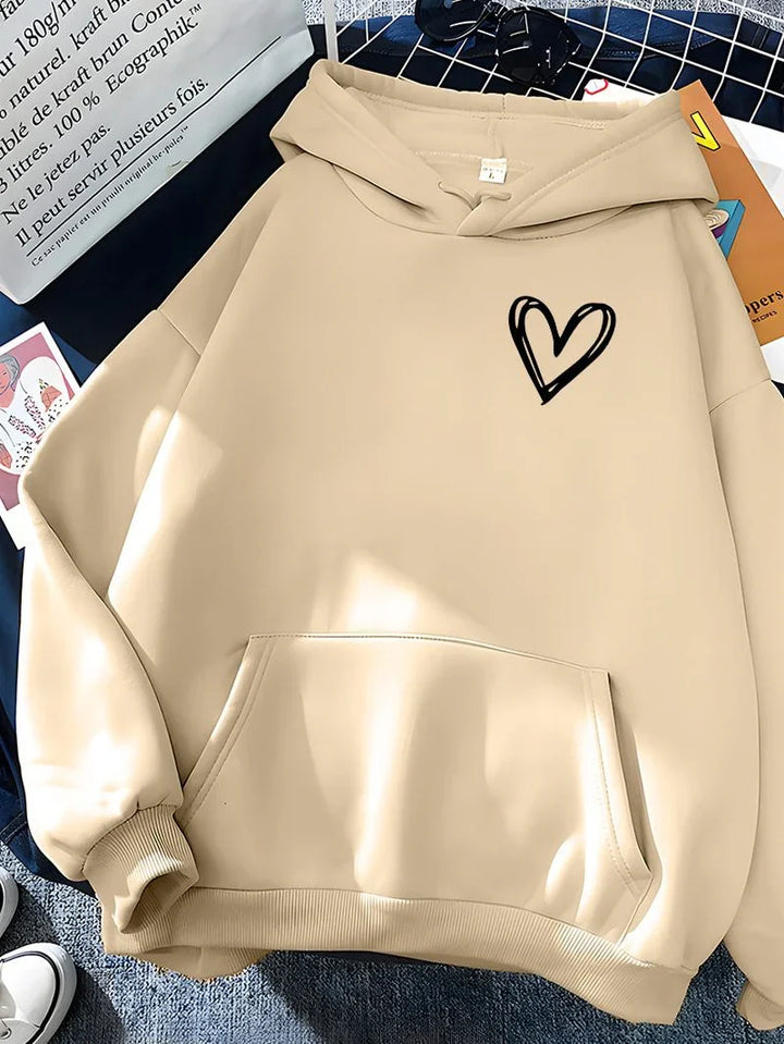Beige hoodie with black hand-drawn heart design, front pocket, and ribbed cuffs on a checkered blue surface