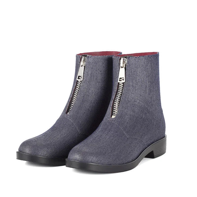 Pair of women's ankle boots with front silver zippers in dark blue fabric and black soles