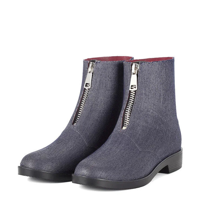 Pair of women's ankle boots with front silver zippers in dark blue fabric and black soles