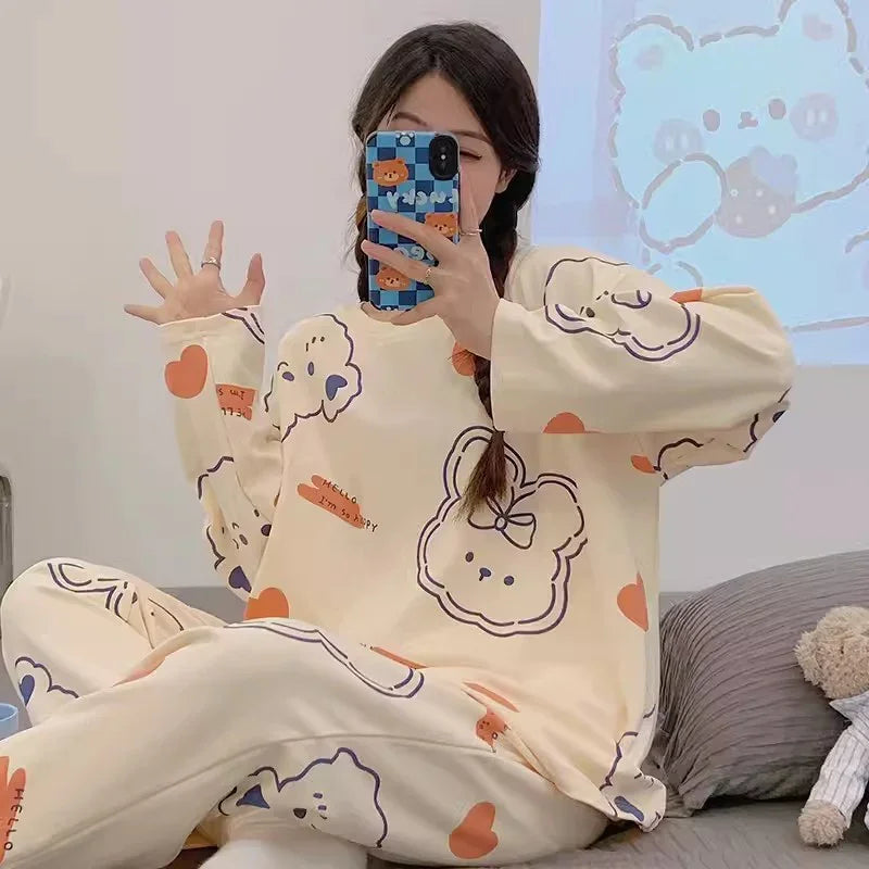 Woman wearing cute cream-colored cartoon bear print pajamas taking mirror selfie in cozy bedroom