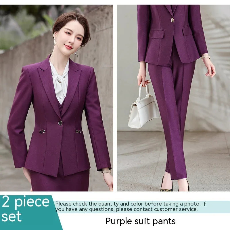 Woman wearing a tailored purple suit with blazer and pants, holding white handbag, formal office outfit