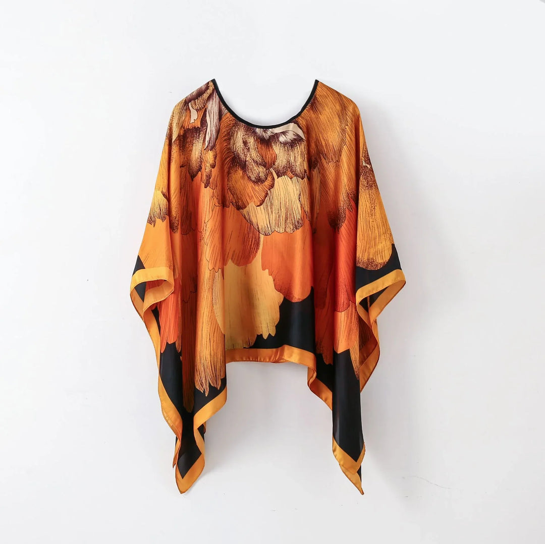 Orange and black floral patterned silk poncho with wide sleeves and asymmetrical hem