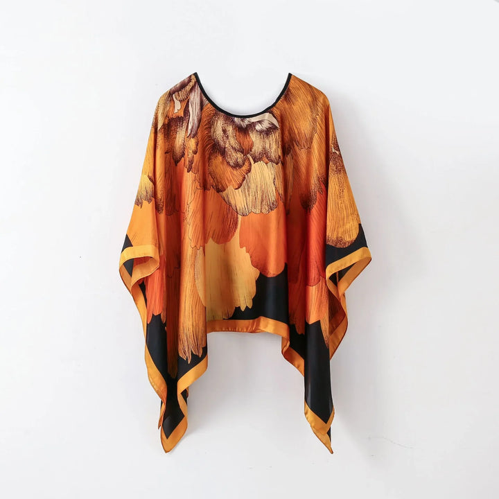 Orange and black floral patterned silk poncho with wide sleeves and asymmetrical hem