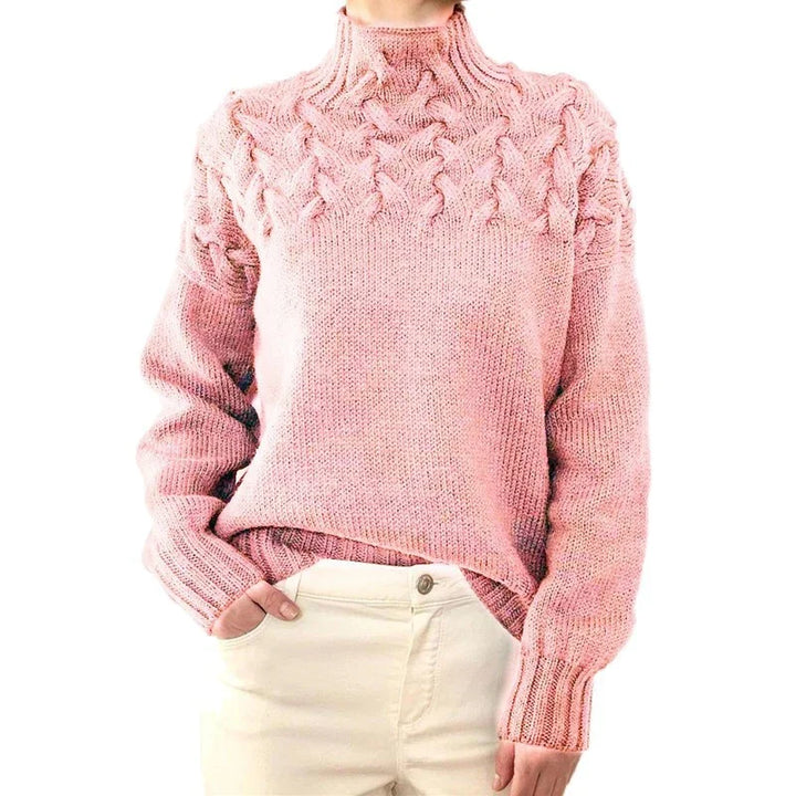 Woman wearing pink cable knit turtleneck sweater with cream pants, hand in pocket, isolated on white