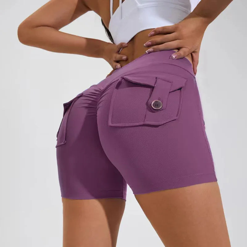 Woman wearing purple high-waisted biker shorts with buttoned back pockets and gathered seam detail