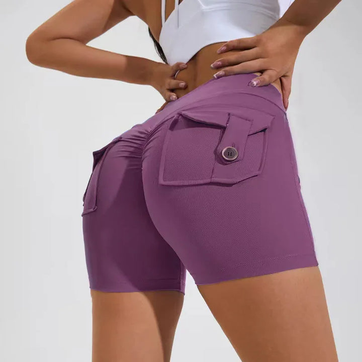 Woman wearing purple high-waisted biker shorts with buttoned back pockets and gathered seam detail