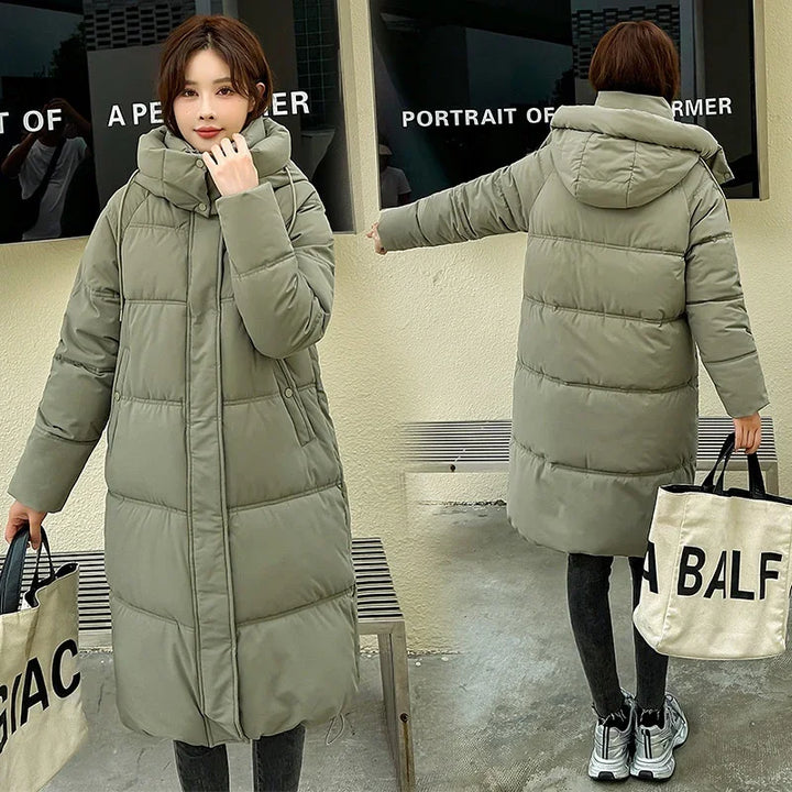 Woman wearing long olive green puffer coat with hood, holding beige tote bag with black text, shown front and back